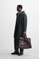 Parka relaxed fit confeccionada en tejido técnico repelente al agua. Interior acolchado desmontable. Cuello solapa con capucha desmontable. Manga larga con puño ajustable con botones a presión. Bolsillos de vivo en cadera. Bajo con abertura central en espalda. Cierre frontal con cremallera oculta por solapa con botones a presión. Chaleco interior acolchado y desmontable con cuello pico y manga sisa.