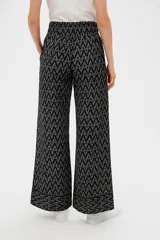 Pantalón de viscosa con estampado geométrico en tonos beige y marrón. Tiene corte ancho, cintura elastizada con cordón y bolsillos laterales.
