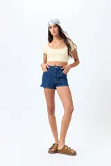 Short de jean de tiro alto, color celeste claro, con bolsillos frontales y traseros, y cierre frontal con botón metálico.