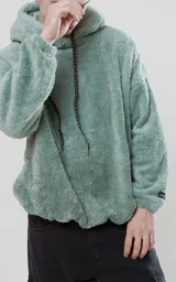 Hoodie verde agua de piel de corderito sintético con calce oversize y cierre central al estilo anorak. La capucha cuenta con cordón ajustable con la palabra Luxo.
