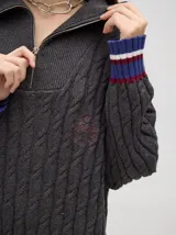 Sweater tejido de algodón color rosa claro, con cuello polo con cierre de cremallera metálica y mangas largas con puños a rayas de colores.