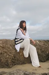 Cartera tejida a crochet con hilo 100% de algodón, con diseño a rayas y volados bordeando la cartera extendiéndose hacia la manija.