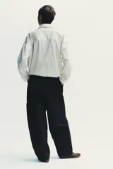 Pantalón cargo negro de corte amplio con cintura ajustable con cordón, bolsillos laterales y bolsillos tipo parche en las piernas.