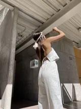 Top beige a rayas verticales, con escote halter y lazos ajustables en el frente y la espalda.