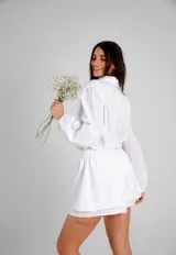 Conjunto blanco símil lino, compuesto por una camisa de manga globo y un short con cintura elastizada.