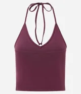 Top cropped de algodón color amarillo pálido, con escote en V pronunciado y tirantes finos que se atan en la nuca (estilo halter). El tejido es acanalado.