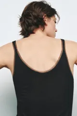 Musculosa blanca de breteles finos y escote redondo con detalle de tul a tono.