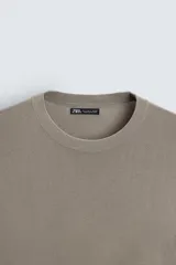 Jersey color topo de corte amplio, tejido en hilatura con mezcla de viscosa. Tiene cuello redondo, manga larga y terminaciones en rib.