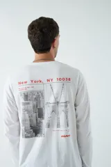 Remera blanca de manga larga con estampado de la ciudad de Nueva York en la espalda.
