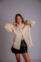 Camisa celeste con estampado de flores blancas, corte clásico, cuello camisero y mangas largas abullonadas.