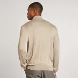 Sweater de punto fino color beige con cuello vuelto y manga larga.