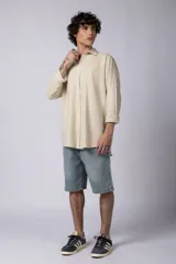 Camisa color arena de lino, manga larga, con cuello clásico y corte holgado.