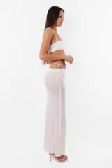 Conjunto de top y falda larga confeccionado en tela con brillos color gris. El top cuenta con arco metálico en el busto, tiras finas para atar en el hombro y ganchos lenceros en la espalda. La falda tiene tiras largas para atar de forma que queden a la vista.