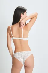 Conjunto de lencería blanco de encaje, compuesto por un corpiño triangular con breteles finos y una bombacha tipo vedetina.