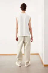 Musculosa blanca de algodón con cuello redondo y sisas sin rematar. Estampado negro con la palabra 'L.A.C.A' en el frente. Corte holgado.