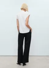 Camisa blanca sin mangas con cuello camisero y cierre frontal con botones.