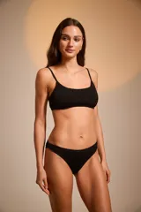 Top de bikini negro con textura arrugada y tirantes finos.