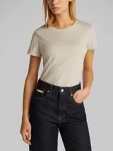 Remera color beige de corte slim, cuello redondo y mangas cortas. Logo de Calvin Klein en relieve estampado en el pecho.