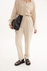 Pantalón de lino color beige, con cintura elástica y cordón ajustable.