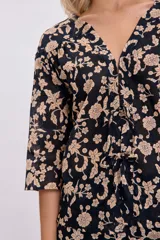 Kimono corto negro con estampado floral en tonos beige, con mangas 3/4 y lazo de ajuste en la cintura.