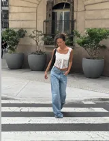 Corset blanco de encaje con escote cuadrado y breteles anchos con detalle de puntilla.