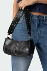 Bolso bandolera negro de cuero sintético con tachas plateadas en las correas.