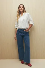 Camisa blanca bordada de algodón con diseño floral y calados, escote en V con cuello mao y mangas largas.