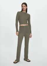 Pantalón de tejido de punto de canalé color verde oliva con lúrex, tiro alto, corte recto, cintura elástica y forro interior.