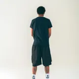 Bermuda de nylon color gris oscuro, con cintura elastizada con cordón, bolsillos laterales y bolsillos cargo con solapa. Estampado blanco con diseño de casa en la pierna izquierda.