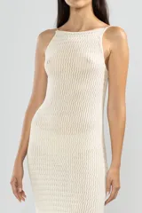 Vestido largo tejido color crema, con cuello halter y espalda baja.