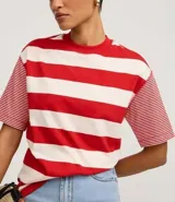 Remera de algodón con cuello redondo, cuerpo a rayas horizontales anchas verdes y blancas, y mangas cortas con rayas horizontales finas verdes y blancas. Presenta sisas desplazadas y costuras aparentes.