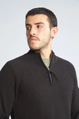 Sweater borgoña de punto acanalado, con cuello alto y medio cierre frontal.