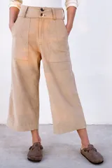 Pantalón capri color beige de pana con tiro alto, corte ancho y bolsillos laterales.