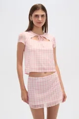 Top negro de poliéster con mangas cortas, cuello redondo, corte ajustado y abertura en el pecho.