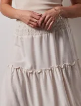 Falda midi a rayas verticales celestes y blancas, con pretina ancha elastizada en punto smock y volados en los cortes.