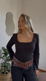 Remera negra de manga larga con cuello cuadrado, confeccionada en jersey térmico.