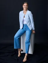 Chaqueta celeste de tweed marca Nanette, con cuello a la base, abertura central y bolsillos delanteros. Puños con aplique de botones perlados y terminación desflecada.
