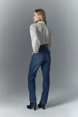 Pantalón de jean de tiro alto, denim azul rígido con lavado oscuro y apliques de brillos.