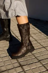 Botas de cuero color chocolate, de caña media con hebillas decorativas y suela track.