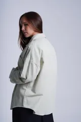 Sobrecamisa color beige de gabardina con cuello camisero, cierre frontal con botones a presión, dos bolsillos de parche en el pecho y corte holgado.