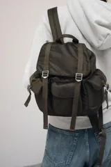 Mochila marrón con múltiples bolsillos con cierre magnético, correas con hebillas, bolsillo interior con cremallera metálica y cierre mediante frunce y solapa con cierre imantado.