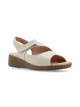Sandalias de cuero color crema, con plataforma marrón y ajuste de velcro.