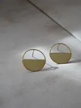 Par de aros dorados con forma circular, divididos horizontalmente: la mitad superior es un aro fino y la mitad inferior es un semicírculo sólido.