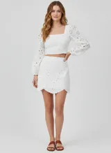 Short pollera blanco de tejido plano de algodón con detalle de puntilla calada.