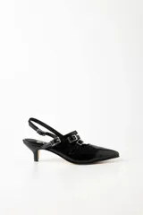 Zapato de charol negro con punta fina, tira sobre el empeine con hebillas plateadas, tira trasera con hebilla y taco kitten heel.