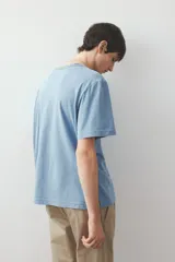 Remera celeste de corte estándar, confeccionada en tejido de punto de algodón de peso medio, con cuello redondo ribeteado acanalado y bajo recto.