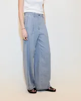 Pantalón gris de lino, de pierna ancha con pinzas, tiro medio, bolsillos laterales inclinados, raya de aplomo y bolsillos traseros ojal y con tapa. Tiene cierre y botón en la cartera y cintura interna prearmada.