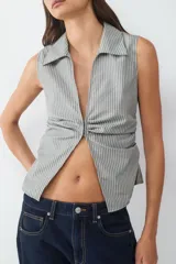 Top sin mangas con escote pico, frunce delantero y bajo ligeramente abierto.