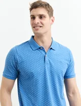 Chomba celeste con estampado de lunares blancos, cuello clásico y mangas cortas.