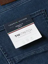 Pantalón de jean azul oscuro, de corte recto, con diseño clásico de cinco bolsillos, cierre de botón con cremallera y logo de la marca en la parte trasera.